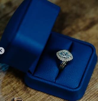 Cushion-cut halo engagement ring in a blue ring box