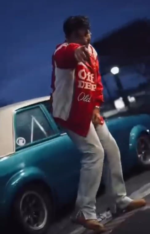 Johnny Martinez leaning on a classic car at night